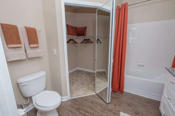 Bathroom with toilet, walk-in closet, and shower bath
