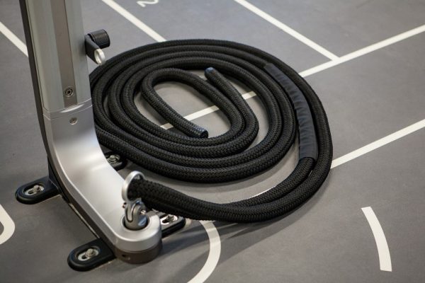 Battle ropes coiled up on the ground in the fitness center
