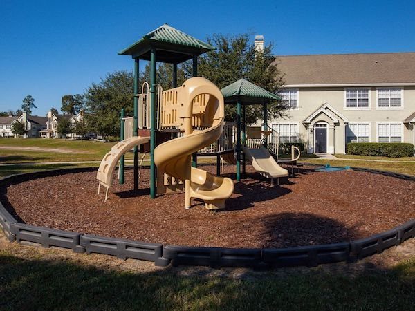 Playground set with slides and climbing walls on a designated mulch area
